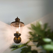 уличный настенный светильник с прозрачным стеклянным плафоном на кронштейне из латуни