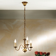 трёхрожковая люстра с изогнутыми держателями и свечеподобными источниками света в патинированном оформлении