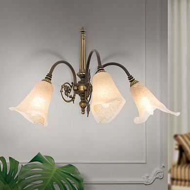 трёхламповое настенное бра с плавно изогнутыми рожками и стеклянными абажурами в патинированной отделке